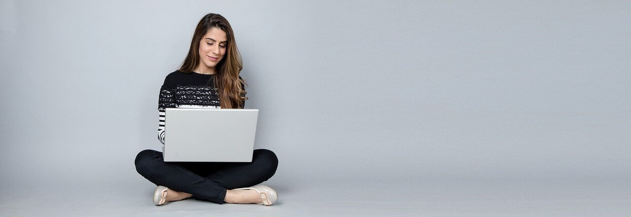 joven fémina sentada utilizando computadora portátil